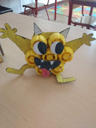 Personagem da história: "Trincas"- monstro amarelo construído com tampas amarelas tendo como base cartão pintado de amarelo. Os olhos e a boca do monstro foram desenhados em cartão.