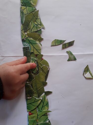 As crianças ajudaram a colar recortes verdes para compor a relva da nossa capa.