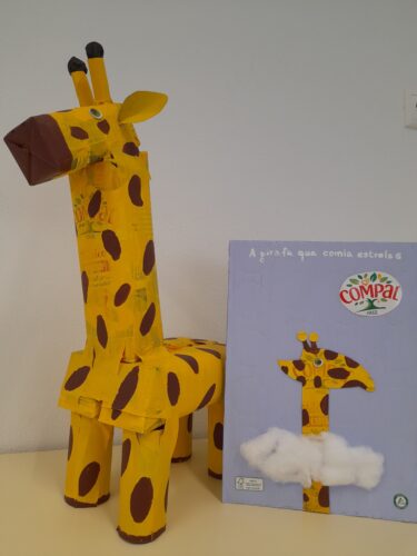 Capa e personagem principal da obra<br/>A capa e a girafa foram elaboradas pelos alunos, com base na obra "A girafa que comia estrelas", trabalhada em sala de aula pela turma de 2º ano.