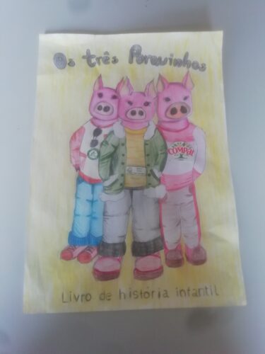 Capa do livro: Os três porquinhos<br/>Esta capa foi pintada por duas alunas do 7º ano, utilizando a técnica do lápis de cor. Nas camisolas dos porquinhos foarm colados os simbolos solicitados.